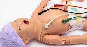 Simulador de recém-nascido com eletrodos ligados aos corpo